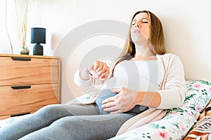 Pregnant pain contractions. Pregnant woman watching clock, holding baby belly. Childbirth time, contractions pain