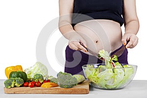 Pregnant person making salad