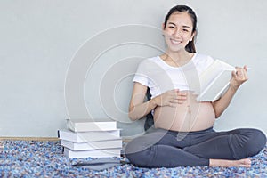 Pregnant reading a book. Pregnant woman reading a book on capet in the living room