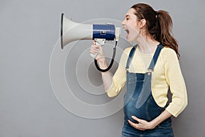 Pregnant screaming woman holding loudspeaker