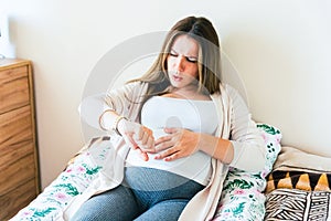 Pregnant time go hospital. Pregnant holding baby belly, woman watching clock. Childbirth time, contractions pain