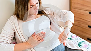 Pregnant time go hospital. Pregnant holding baby belly, woman watching clock. Childbirth time, contractions pain