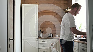 A pregnant wife and her husband have breakfast in the Scandinavian style kitchen. pregnant woman sitting on a table in