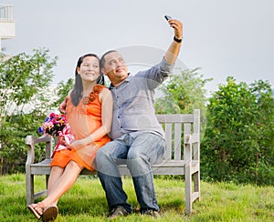 Pregnant Wife and Husband Taking Cell Phone Picture .