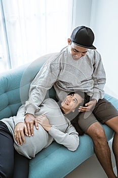 A pregnant wife lies on her husband`s lap while relaxing