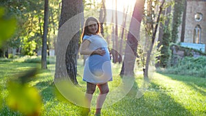 Pregnant woman 9 month smiling against sunrise