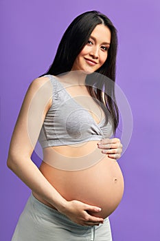 Pregnant woman with 9 months of exciting expectations behind, holds her tummy