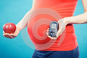 Pregnant woman with apple and glucose meter with good result sugar level, diabetes and nutrition during pregnancy