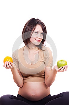 Pregnant woman with an apple and an orange