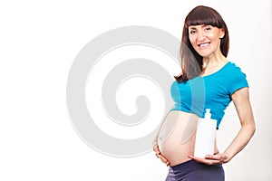 Pregnant woman applying moisturizing lotion on belly, avoid stretch marks