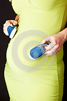 Pregnant woman with baby shoes