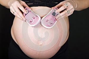 Pregnant woman and baby shoes