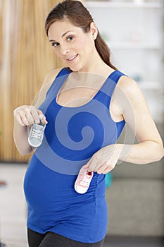 pregnant woman with baby shoes in baby room