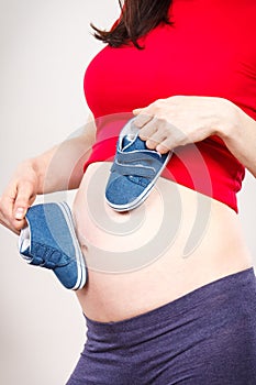 Pregnant woman with baby shoes, expecting for baby