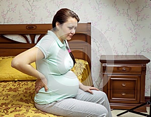 Pregnant woman back pain. Pregnant in her bedroom