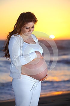 Pregnant woman at the beach during sunset