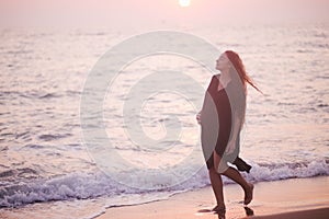 Pregnant woman beauty with long hair walking at the beach.