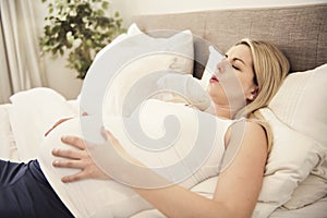 Pregnant woman on the bed at home having contractions