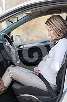 Pregnant woman behind the steering wheel having contractions