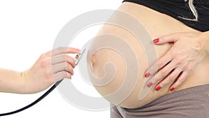 Pregnant woman being examine by a doctor with a stethoscope, white, closeup