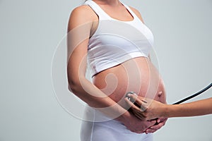 Pregnant woman being examine with stethoscope