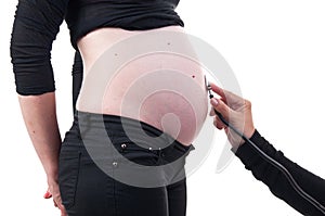 Pregnant woman being examined by a doctor with a stethoscope iso