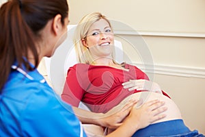 Pregnant Woman Being Given Ante Natal Check By Nurse