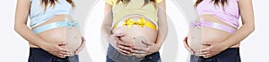 Pregnant woman belly with bow, pink, blue and yellow