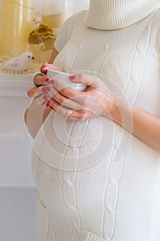 Pregnant woman belly with cup