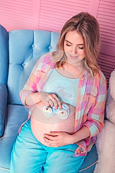 Pregnant woman belly holding baby booties