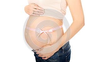 Pregnant woman belly with pink ribbon gift