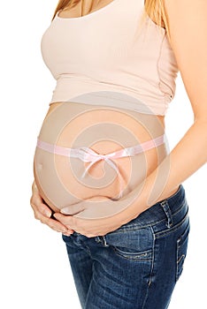 Pregnant woman belly with pink ribbon gift