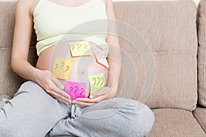 Pregnant woman belly with question mark. Pregnancy and thinking problem