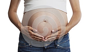 A pregnant woman with a big belly in the late term touches his hands. Close-up. Front view. Isolated on a white background.