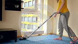 Pregnant woman with big belly vacuum clean hoover room