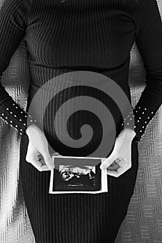 pregnant woman black dress lies bed snapshot