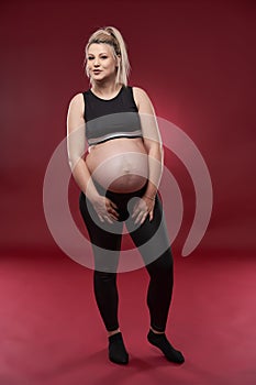 Pregnant woman in black over red background