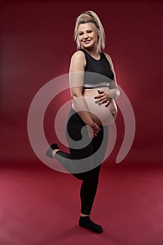 Pregnant woman in black over red background