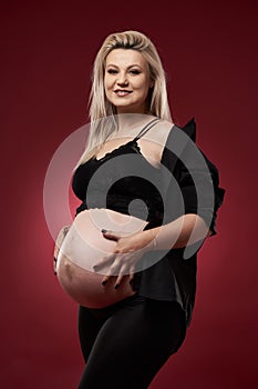 Pregnant woman in black over red background