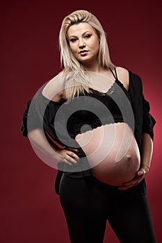 Pregnant woman in black over red background