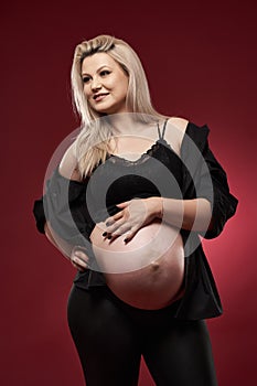 Pregnant woman in black over red background