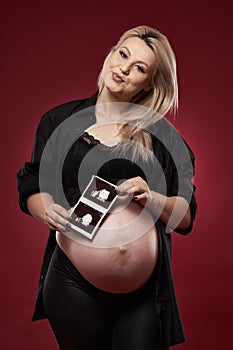 Pregnant woman in black over red background