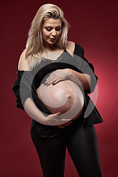 Pregnant woman in black over red background