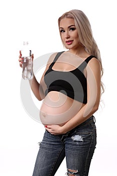 Pregnant woman with bottle of water. Close up. White background