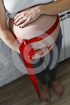 Pregnant woman with a bow around her stomach