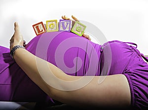 Pregnant woman with building blocks on her belly