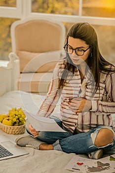 Pregnant woman carefully reading the working paper