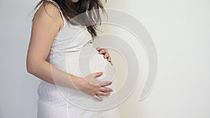 Pregnant woman caressing her belly, waiting miracle of birth, purity feeling, close up, detail