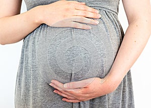 Pregnant woman caring and sharing love with her baby by touching her belly