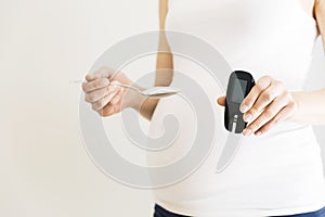 Pregnant woman checking blood sugar level. Gestational diabetes.